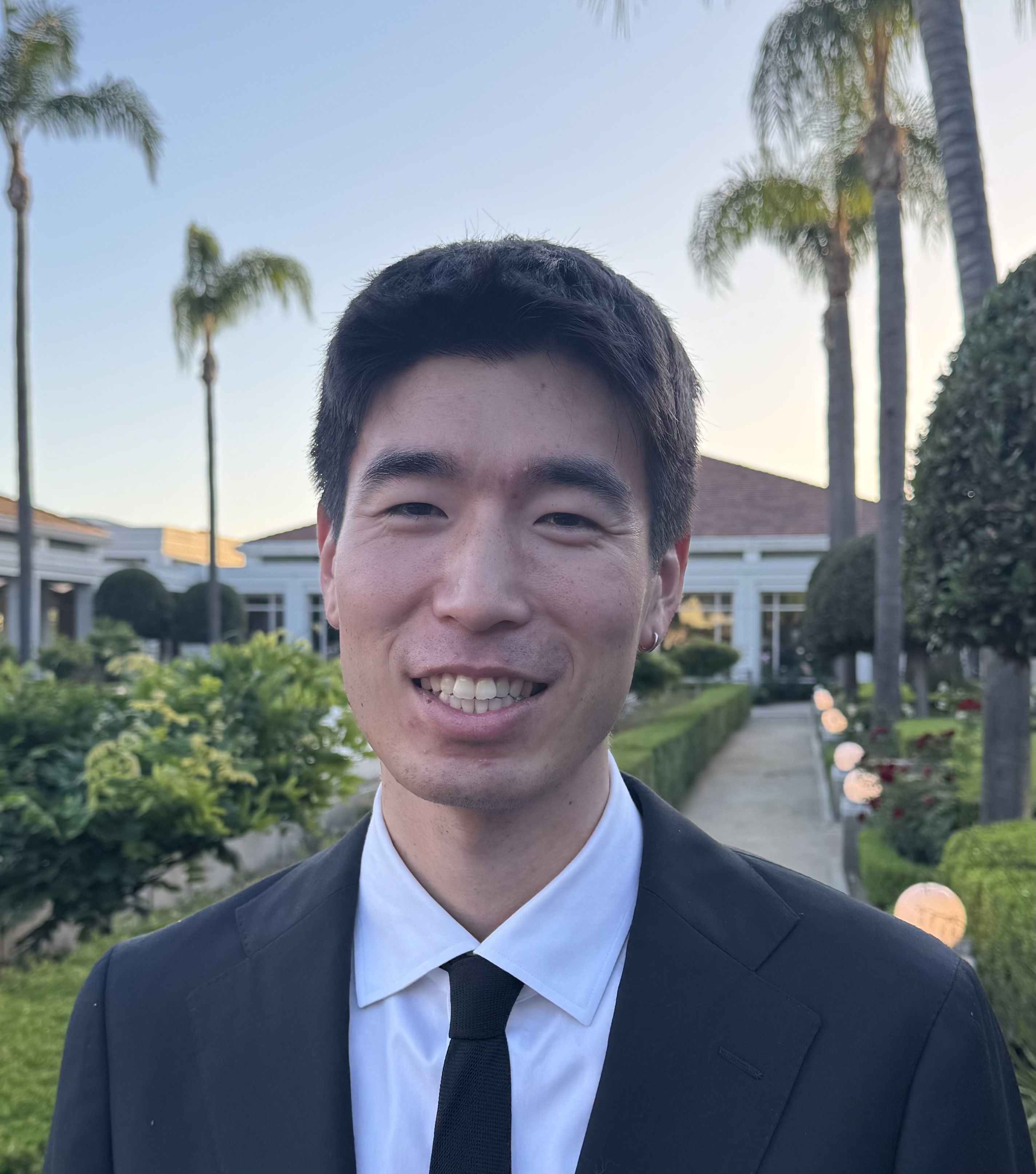 Brian Loh in a suit outdoors in a landscaped garden